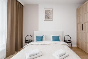 ein Schlafzimmer mit einem großen weißen Bett mit blauen Kissen in der Unterkunft Warsaw City Family Premium in Warschau