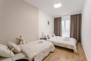 ein weißes Schlafzimmer mit 2 Betten und einem Sofa in der Unterkunft Warsaw City Family Premium in Warschau
