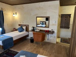 a bedroom with a bed and a desk with a mirror at Virtus Cappadocia Hotel Göreme in Goreme