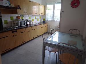 een keuken met een tafel en stoelen en een aanrecht bij Maison de vacances très agréable LA BAULE in La Baule