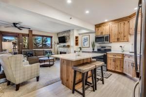 a kitchen with wooden cabinets and a living room at Laurelwood Condominiums 107 in Snowmass Village