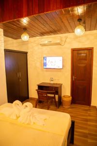 a room with two beds and a table with a desk at Sea Turtles Bungalow in Bentota