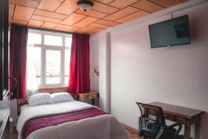 a bedroom with a bed and a tv on the ceiling at Hotel El Morlaco in Cuenca