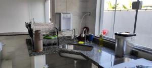 a kitchen counter with a sink and a phone at Casa Praia Itanhaém - Avenida Santos in Itanhaém