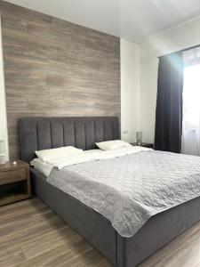 uma cama grande num quarto com piso em madeira em ApartHotel em Mukacheve