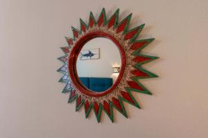 a mirror on a wall with a red and green frame at Il Cagliarese B&B in Cagliari