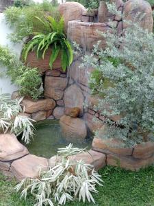 een tuin met een vijver en een waterval bij Ranagiri Relaxing Bungalow in Bentota