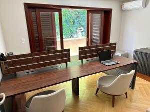 a room with a desk with a laptop and chairs at Job&Joy Business Hostels in Campinas