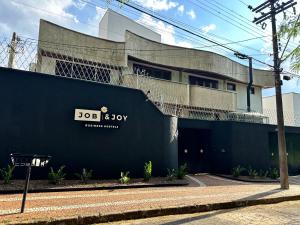 a building with a sign on the side of it at Job&Joy Business Hostels in Campinas