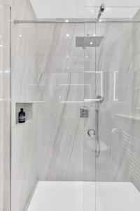 a bathroom with a shower with a glass door at Luxury 3 bedroom apartment in the heart of High Street Kensington, London. in London