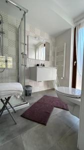 y baño con ducha, bañera y lavamanos. en Garda View Apartment, en Tenno