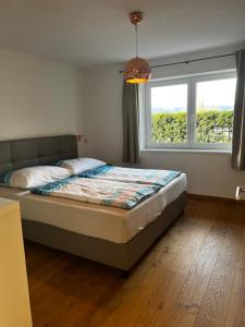 ein Schlafzimmer mit einem Bett und einem großen Fenster in der Unterkunft Apartment Am Birkenweg in Oberndorf in Tirol