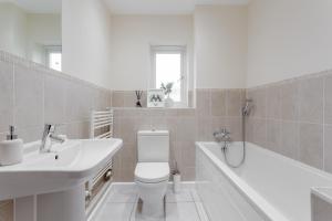 a white bathroom with a sink and a toilet and a tub at Premium Nights - Harry Potter, Professional, Family stay in Watford