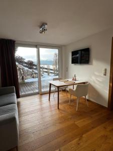 a living room with a table and a large window at Apartment Am Birkenweg in Oberndorf in Tirol