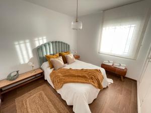 ein Schlafzimmer mit einem großen Bett und zwei Fenstern in der Unterkunft Casa Pepita by the sea in Torrenueva