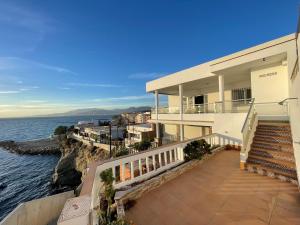 ein großes weißes Haus mit einer Treppe zum Meer in der Unterkunft Casa Pepita by the sea in Torrenueva