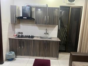 a kitchen with wooden cabinets and a sink at Prime Plaza in Gujrānwāla
