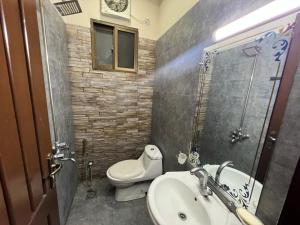 a bathroom with a toilet and a sink and a shower at Prime Plaza in Gujrānwāla