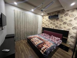 um quarto com uma cama e uma parede em Prime Plaza em Gujrānwāla