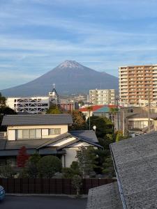 a mountain in the background of a city with buildings at MR TOMO FUJI in Fuji