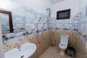 een badkamer met een douche, een toilet en een wastafel bij Prasith’s Place in Mirissa