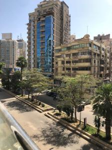 a street in a city with tall buildings and trees at Luxury apartment in Mohandiseen in Cairo