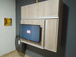 un monitor de ordenador en un armario de madera en una habitación en Rosetta en Malargüe