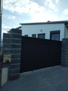 a black gate in front of a white house at Chez Monblanc in Saint-Joseph