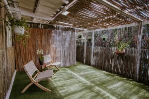 a patio with two chairs and a fence with plants at Lavender BnB in East London