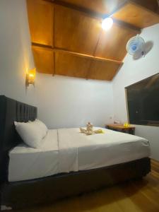 a bedroom with a bed with a teddy bear on it at Poetri Bungalow & Restaurant in Senaru