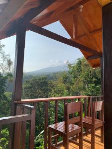 a porch with two chairs and a view of the mountains at Poetri Bungalow & Restaurant in Senaru