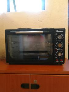 a black microwave sitting on top of a wooden cabinet at Blue Oasis Apartments in Benoni +18 photos