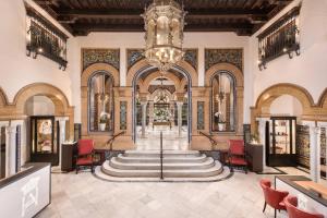 セビリアにあるHotel Alfonso XIII, a Luxury Collection Hotel, Sevilleの大きなシャンデリアと階段のあるロビー