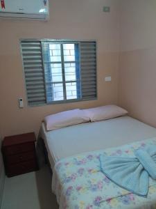 um quarto com 2 camas e uma janela em Hotel Vitoria Andradina em Andradina