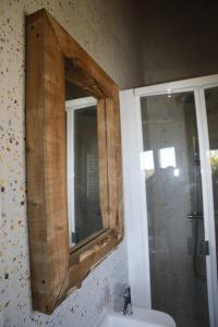 La salle de bains est pourvue d'un miroir avec un cadre en bois au-dessus d'un lavabo. dans l'établissement Casa da Teresinha, à Bragance 30 autres photos