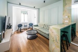 een woonkamer met een bank en een tafel en stoelen bij City Center Design Apartments in Sarajevo
