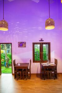 a dining room with purple walls and wooden floors at Sea Turtles Bungalow in Bentota