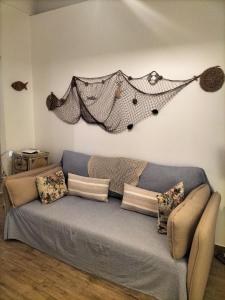 un divano in soggiorno con una coperta sul muro di La Conchiglia Tra i Due Mari a Trapani