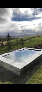 ein großer Wasserpool auf einem Feld in der Unterkunft Luxurious large home Perfect for your group in Hafnarfjördur