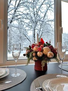 a table with a vase of christmas decorations on a table with glasses at Comfort Apartment In Narva City Center in Narva