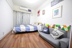 1 dormitorio pequeño con 1 cama y 1 sofá en 新宿中心JR线新大久保徒步3分钟紧邻韩国街免费Wi-Fi02, en Tokio