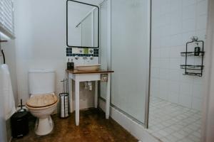 a bathroom with a toilet and a sink and a shower at Lavender BnB in East London