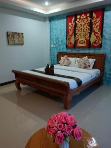 a bedroom with a bed and a vase of flowers at พลอยไพลินPLOYPAILIN in Pai