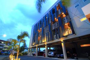 a building with cars parked in a parking lot at Cool Residence - SHA Plus in Phuket Town