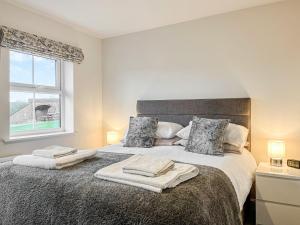 a bedroom with a bed with two towels on it at Crawshaw Cottage in Buxton