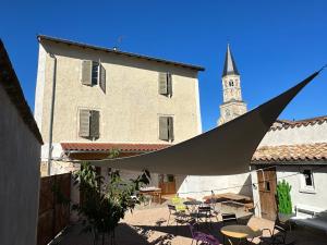 a view of a building with a clock tower at La maison du village in Romanèche-Thorins