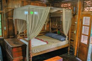 Bett mit Baldachin in einem Zimmer in der Unterkunft Omah kayu bromo in Ngadisari
