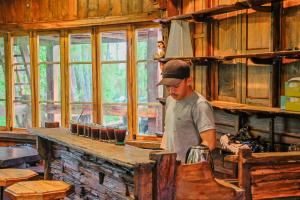 a man standing in a kitchen in a room at Omah kayu bromo in Ngadisari