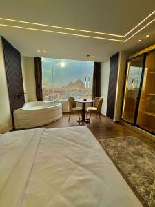 a hotel room with a tub and a table and a bed at Rotana Pyramids View in Cairo