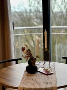 uma mesa com uma vela e um vaso com flores em City Pulse Apartment em Waterford